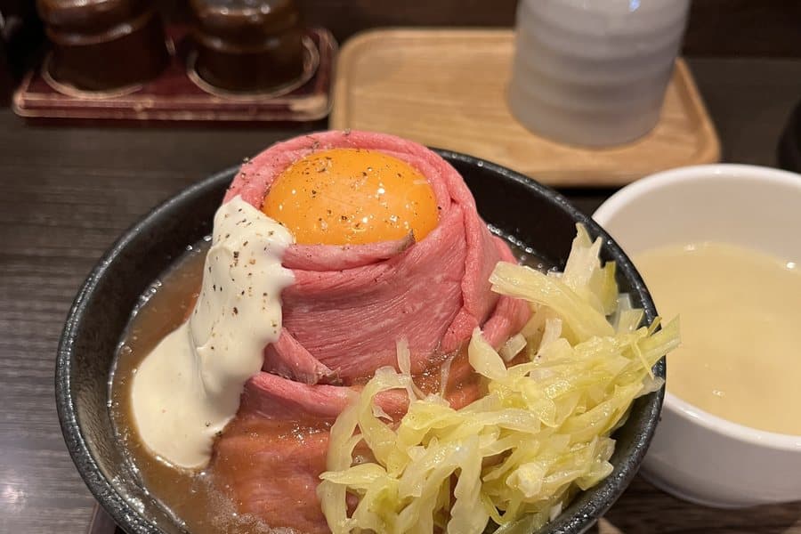 A roast beef rice bowl topped with an egg yolk, in Tokyo.